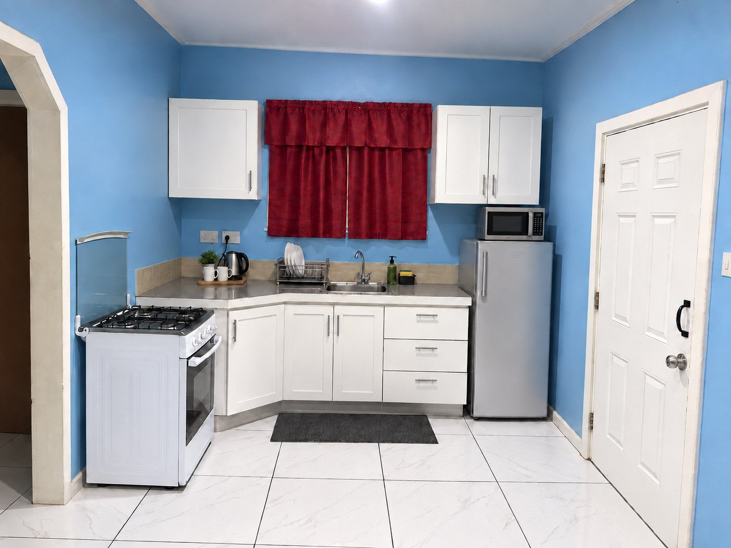 Kitchen with a full-size gas cooker, a full-height fridge freezer, microwave and electric kettle.