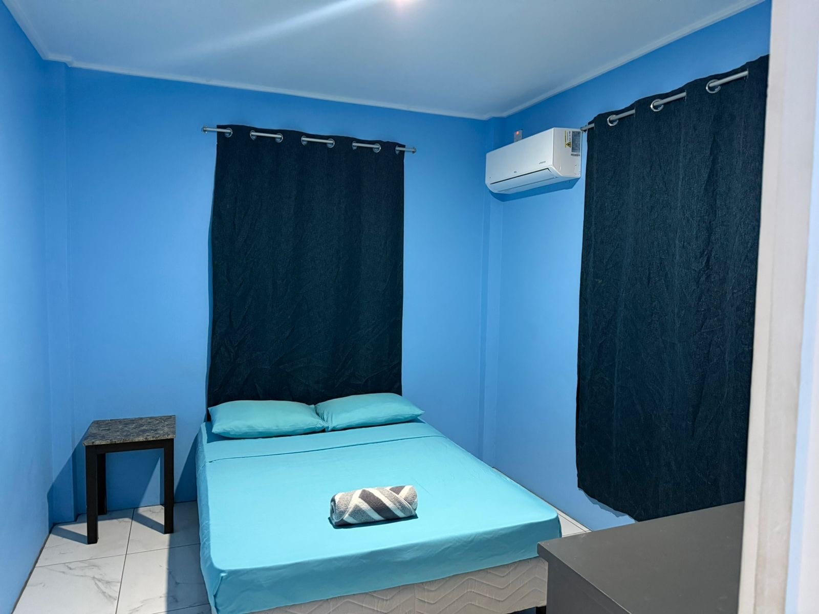 Bedroom with a full-size double bed, air conditioning and blackout curtains.